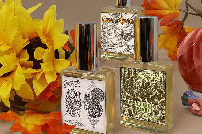 Autumn-scented new perfumes by Love Potion with a brown background, red crystal, fall leaves, and sunflowers.