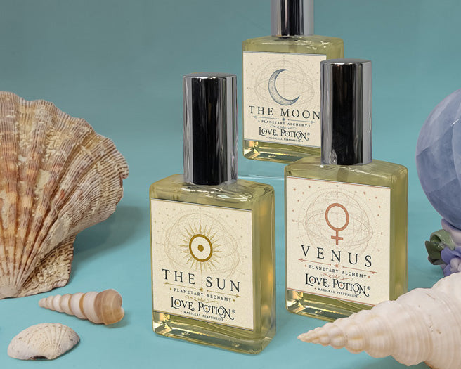 Summer-scented new perfumes by Love Potion with a teal background, blue crystal, and various seashells.