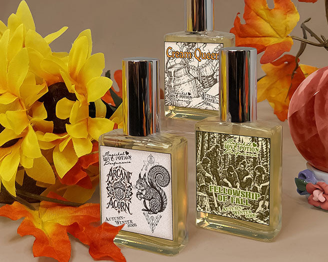 Autumn-scented new perfumes by Love Potion with a brown background, red crystal, fall leaves, and sunflowers.
