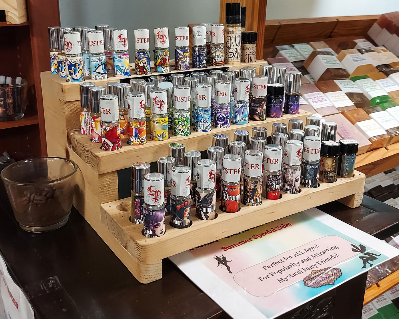 Collection of small pheromone-free perfume tester bottles on a wooden stand with an info sheet underneath.