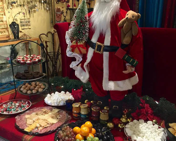 Decorative setup with Santa Claus figure, food platters, and festive decorations in our store during a Christmas party.