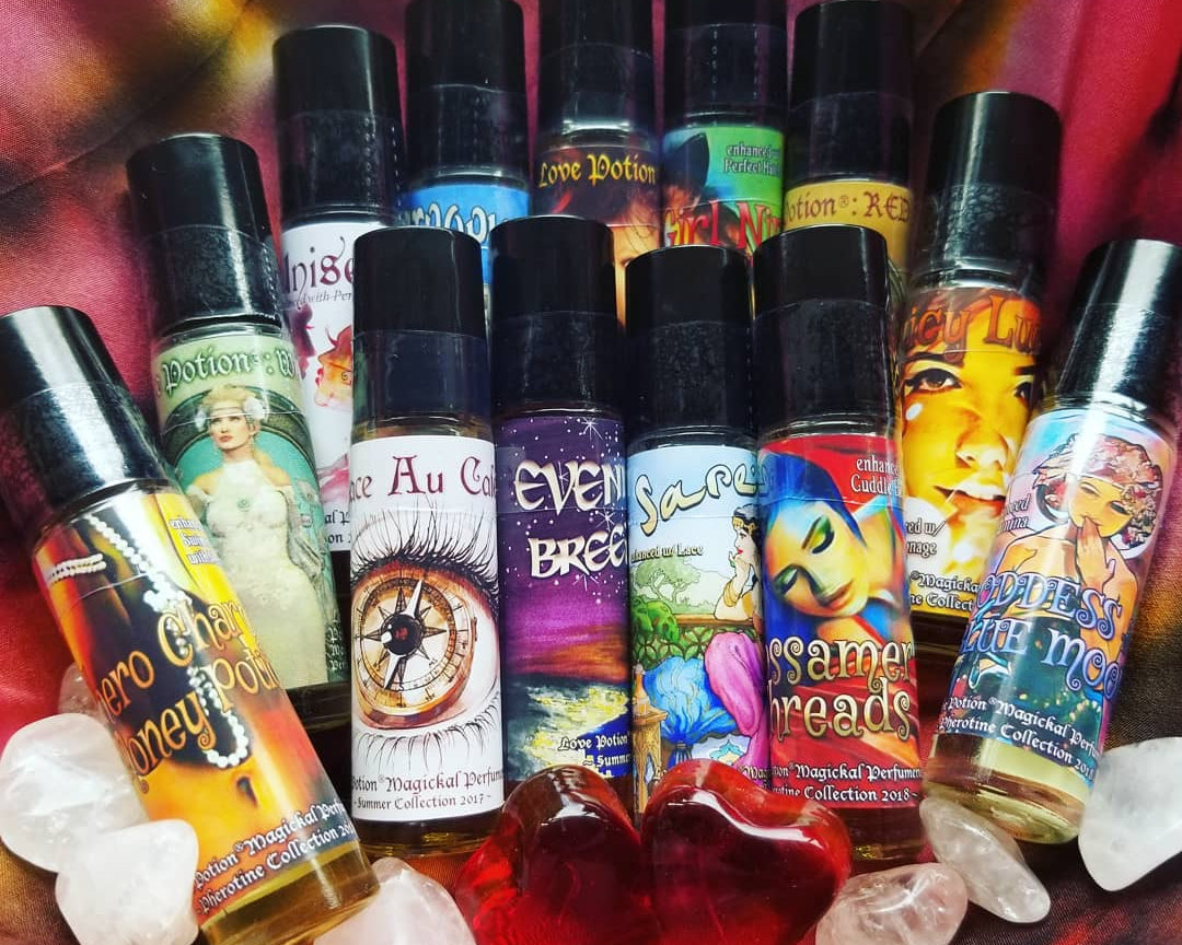 Collection of popular oil perfumes and pheromone bottles with crystals on a tie-dye cloth.