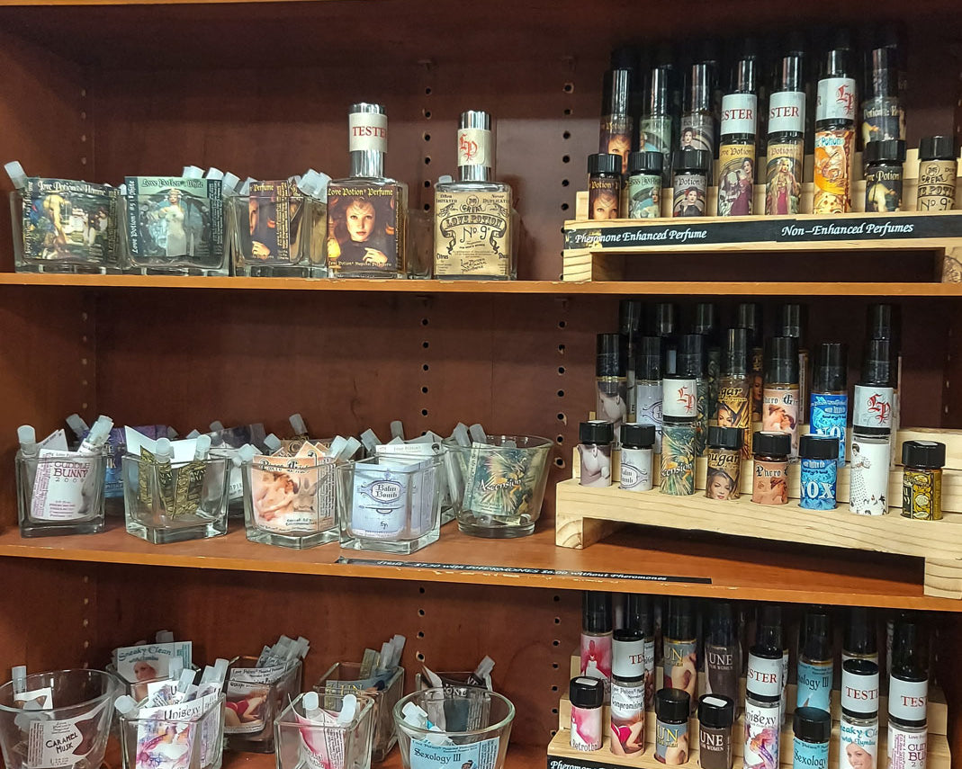 Shelves featuring perfumes from our Permanent Collection and handmade apricot and soy body creams in jars.