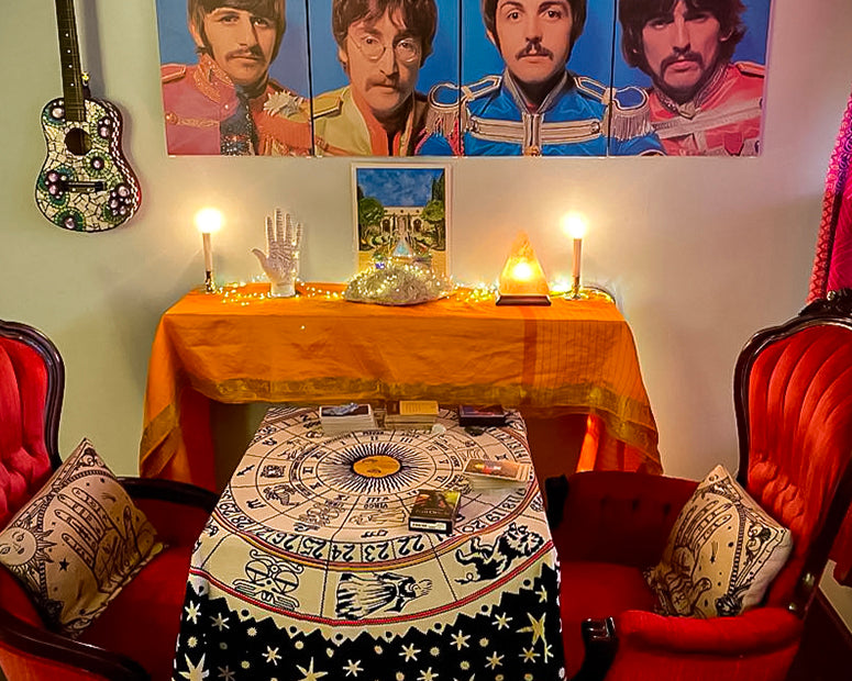The divination area in our Room of Requirement, with red velvet chairs, a card table, and paintings of The Beatles on the wall.