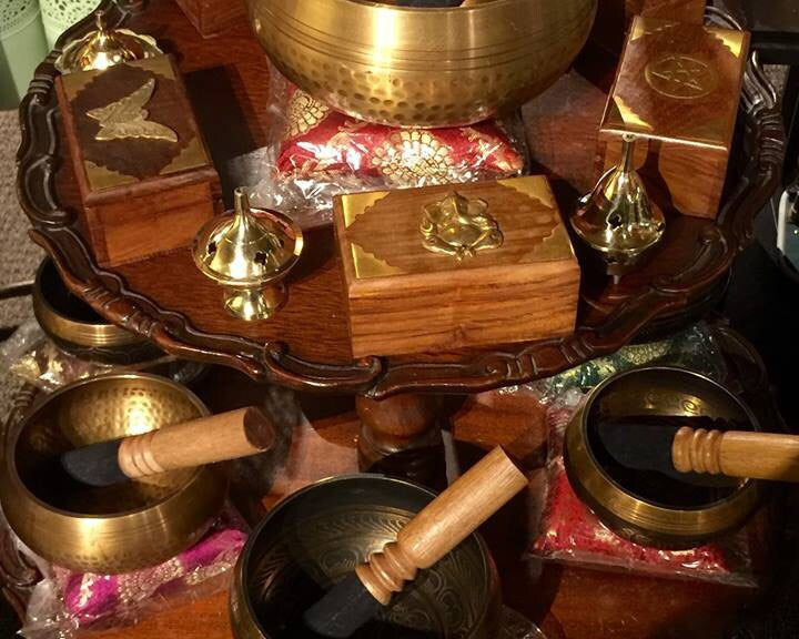 Set of Tibetan singing bowls on a wooden stand with various accessories.