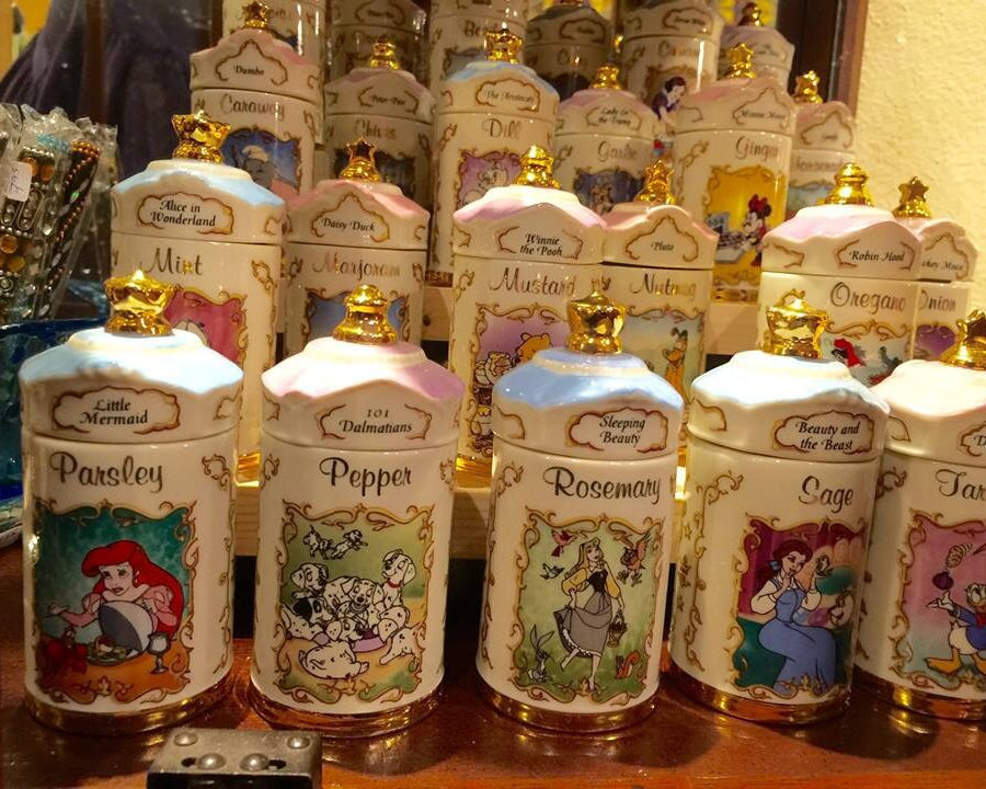 Collection of vintage spice jars with different Disney characters on each jar.