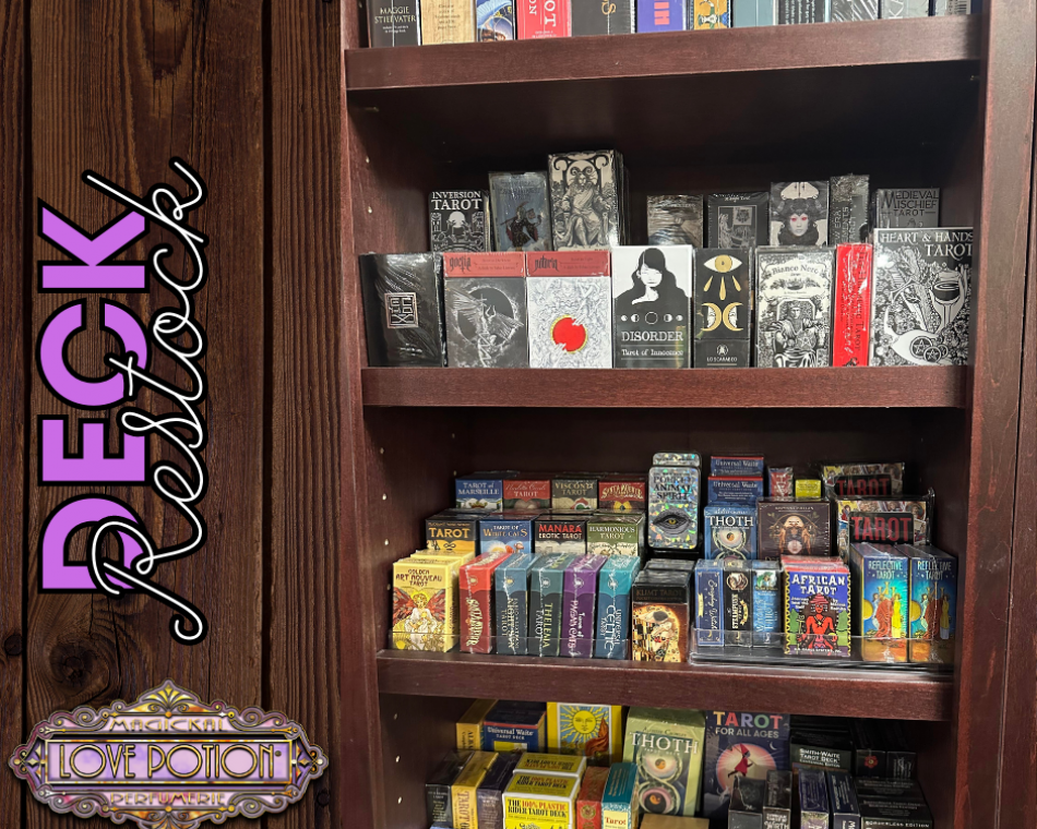 Our wall of tarot, oracle, lenormand, and other divination decks within the shop.