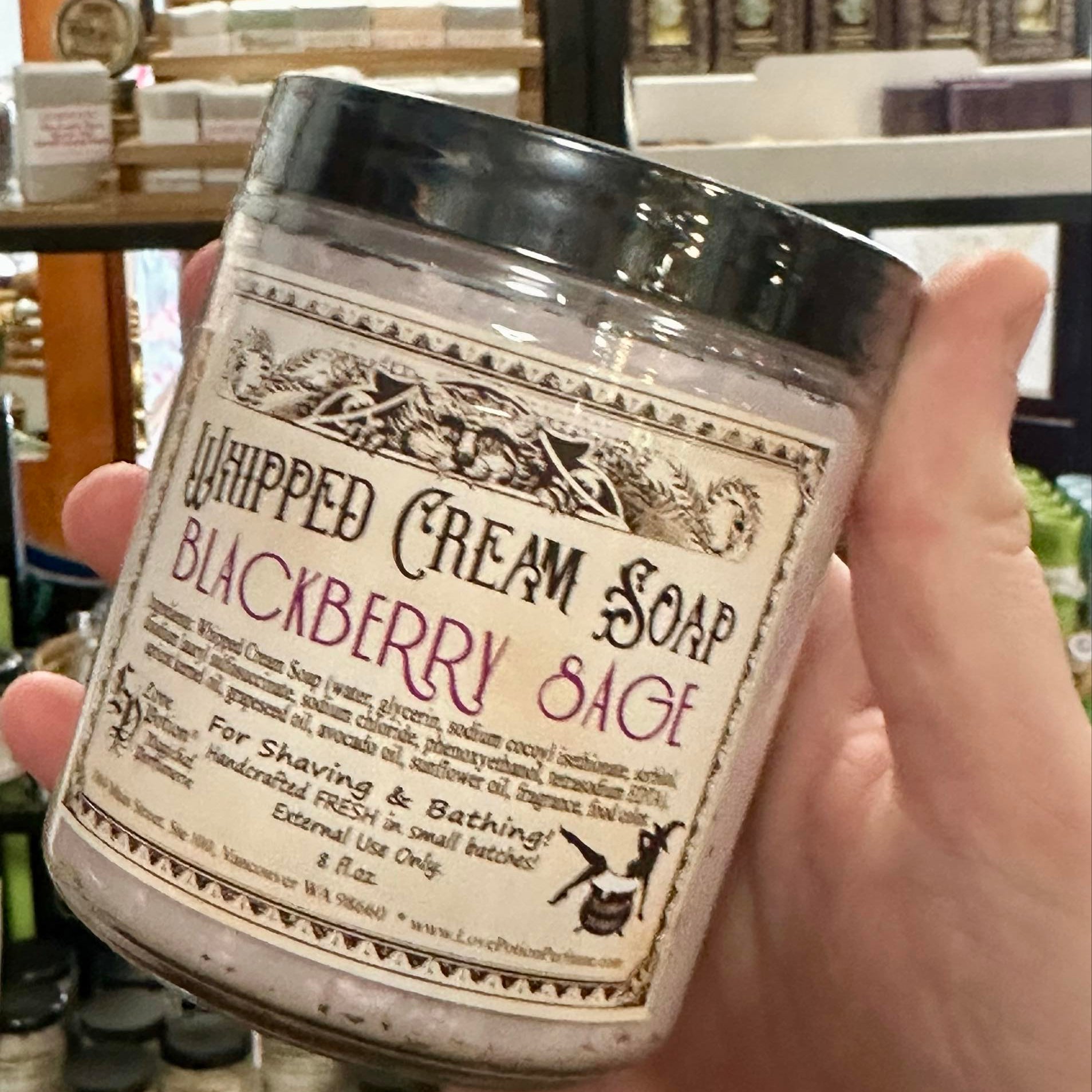 Love Potion whipped cream soap in a jar held by someone at the Love Potion Magickal Marketplace