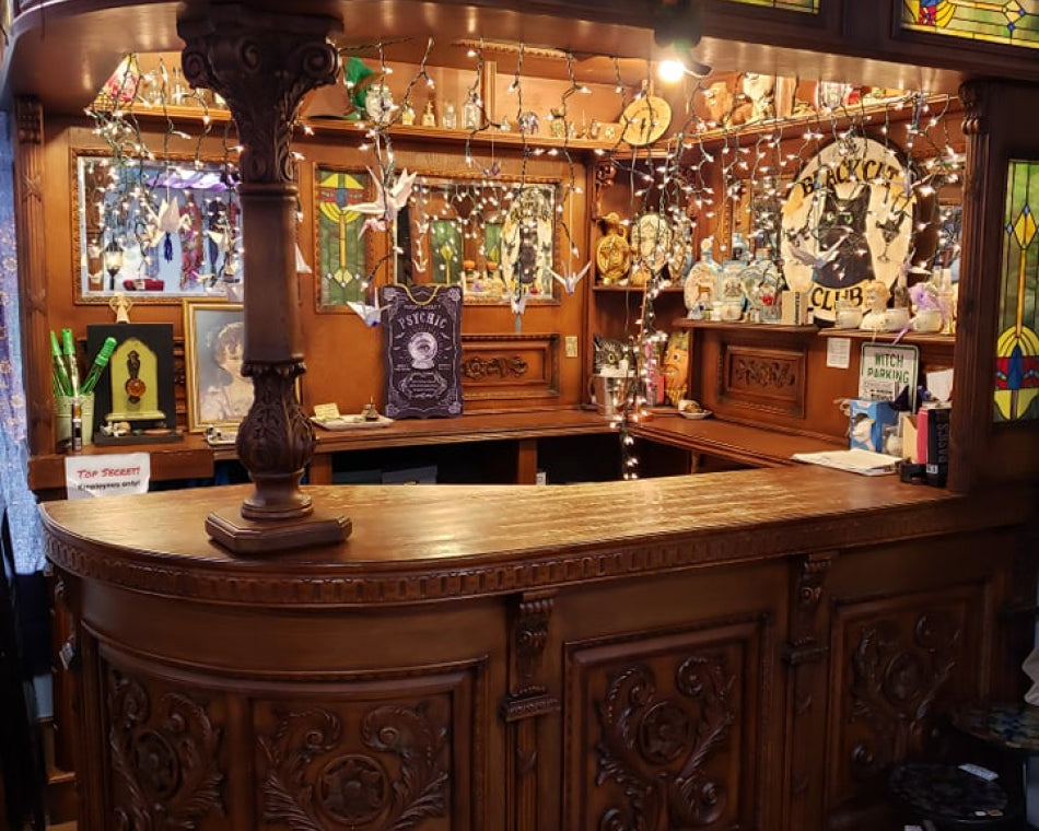 Wooden bar with stained glass panels and various magical decorations and fairy lights, custom-build for Love Potion.
