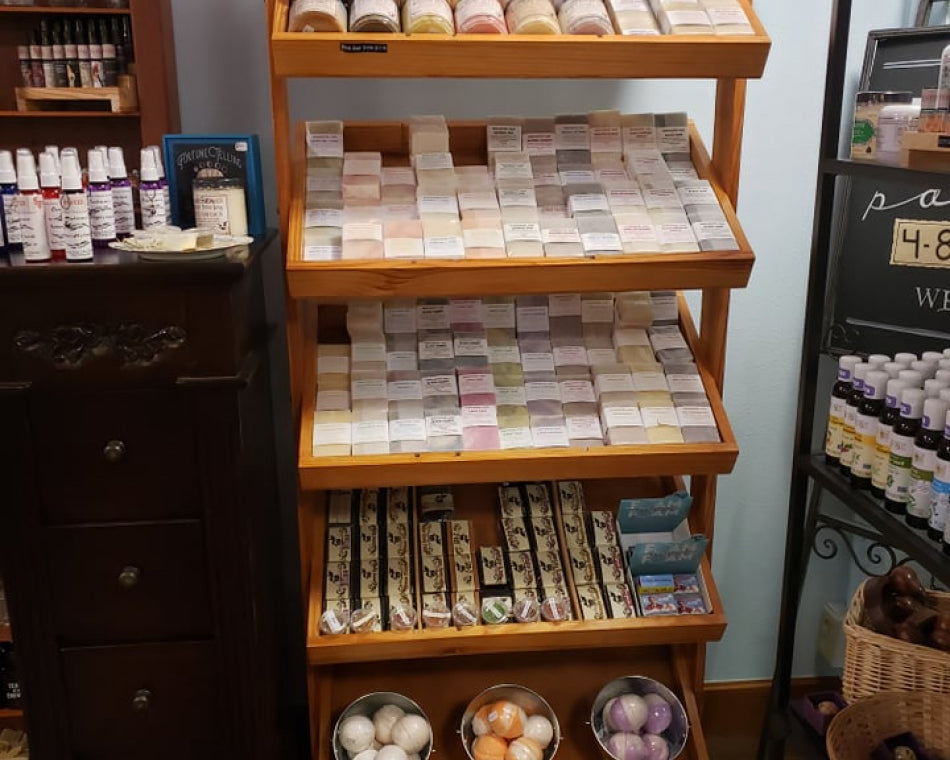 Luxurious bath products: scrubs, soaps, and bath bombs on a shelf displayed in the shop.