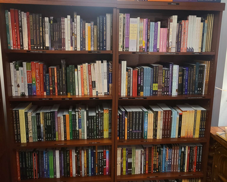 Large bookshelves cover this wall in our shop, displaying books about magic and spirituality.