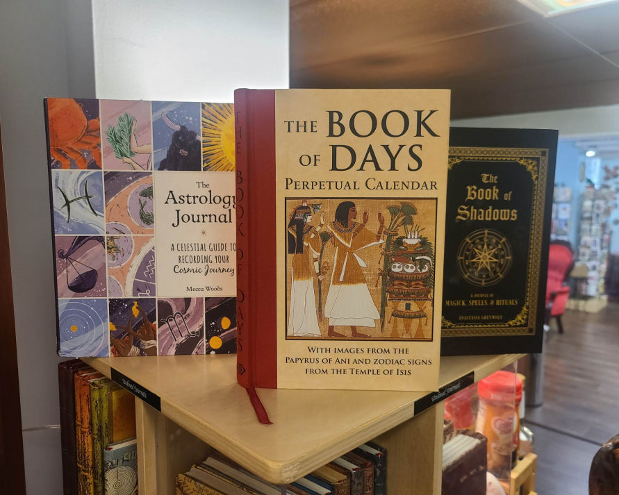 Some books you might find on our shelves: The Astrology Journal, The Book Of Days, and Book Of Shadows.