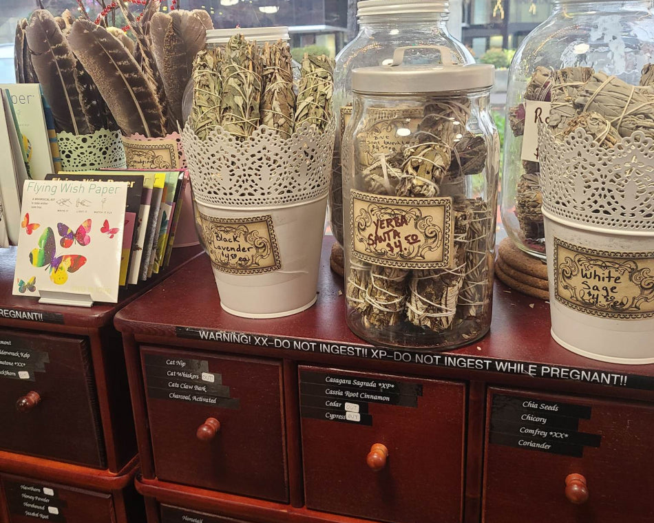 Our spell cabinet, with an assortment of feathers, herbs, and rose petal sage showcased beautifully.