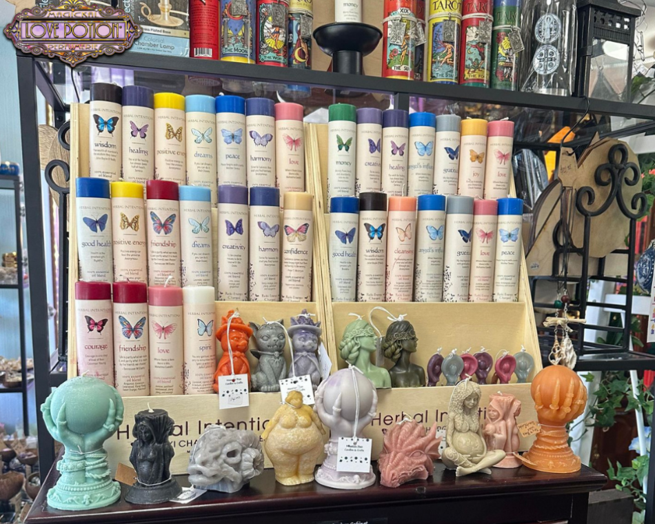 Tarot candles in a selection of colors, themed candles, and locally crafted candles arranged on a three-tier display.