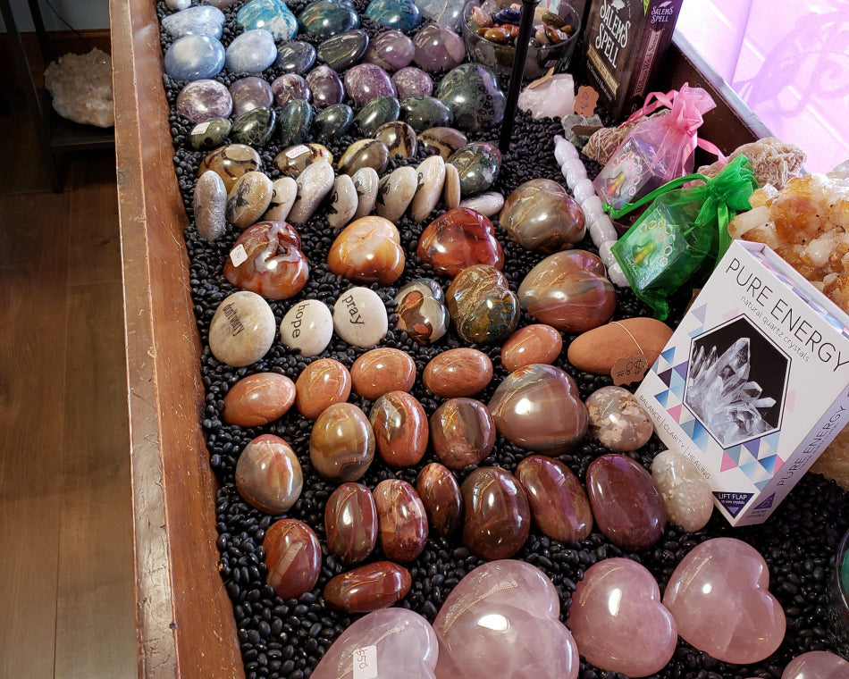 Assorted shapes and sizes of crystal hearts and worry stones.
