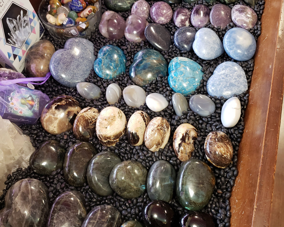 Assorted shapes and sizes of crystal hearts and palm stones.
