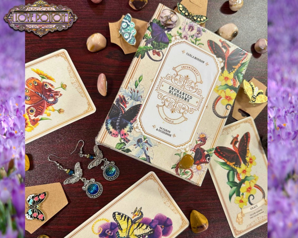 Enchanted Blossoms Oracle Deck by Carla Morrow surrounded by sample cards and butterfly jewelry.