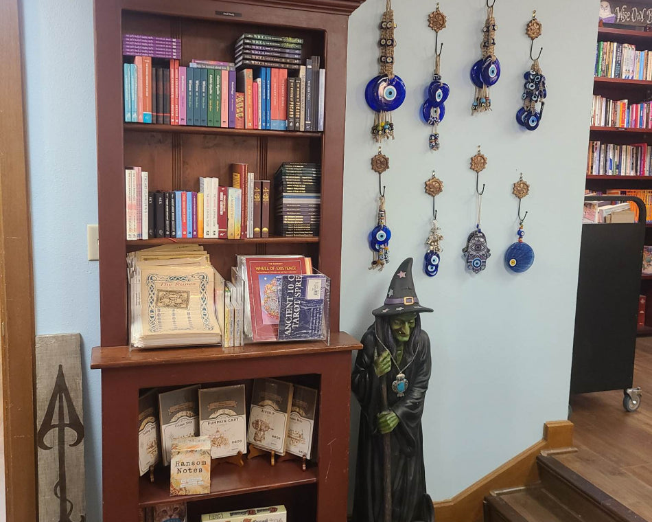Shelves filled with exciting games and novelty books. On the wall are Nazar evil eye protection wall charms.