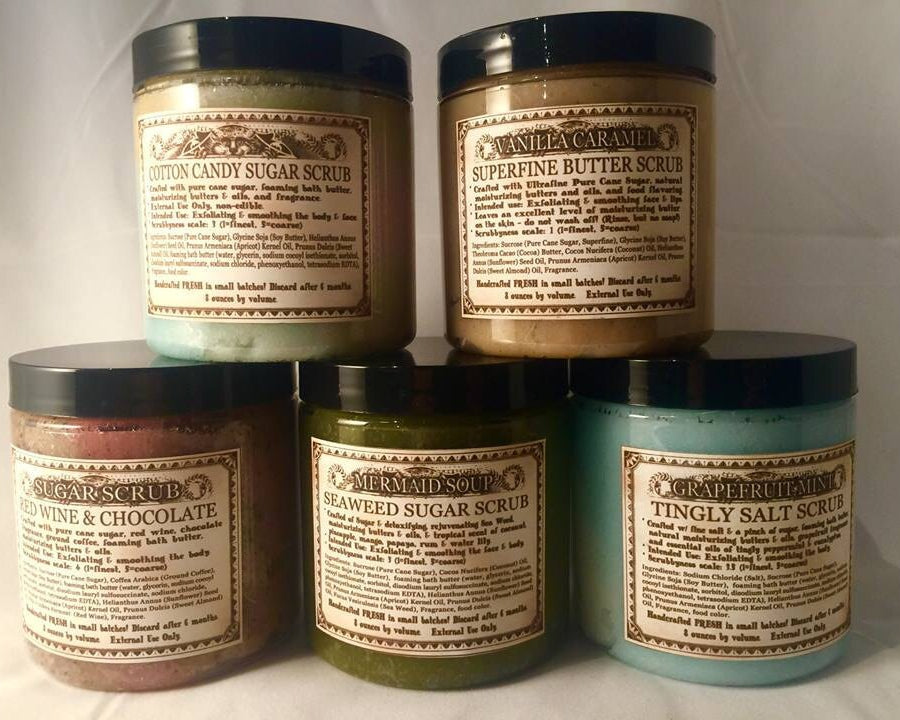 Collection of handmade Love Potion sugar scrubs with labels on a white background.