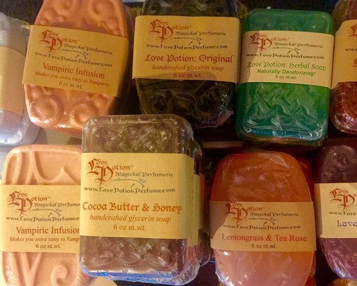Assorted handcrafted Love Potion scented glycerin soaps with visible labels on a white background.