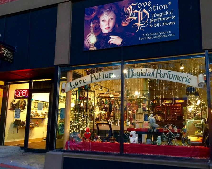 Storefront of Love Potion Magical Perfumerie & Gift Shoppe with decorative display and sign.