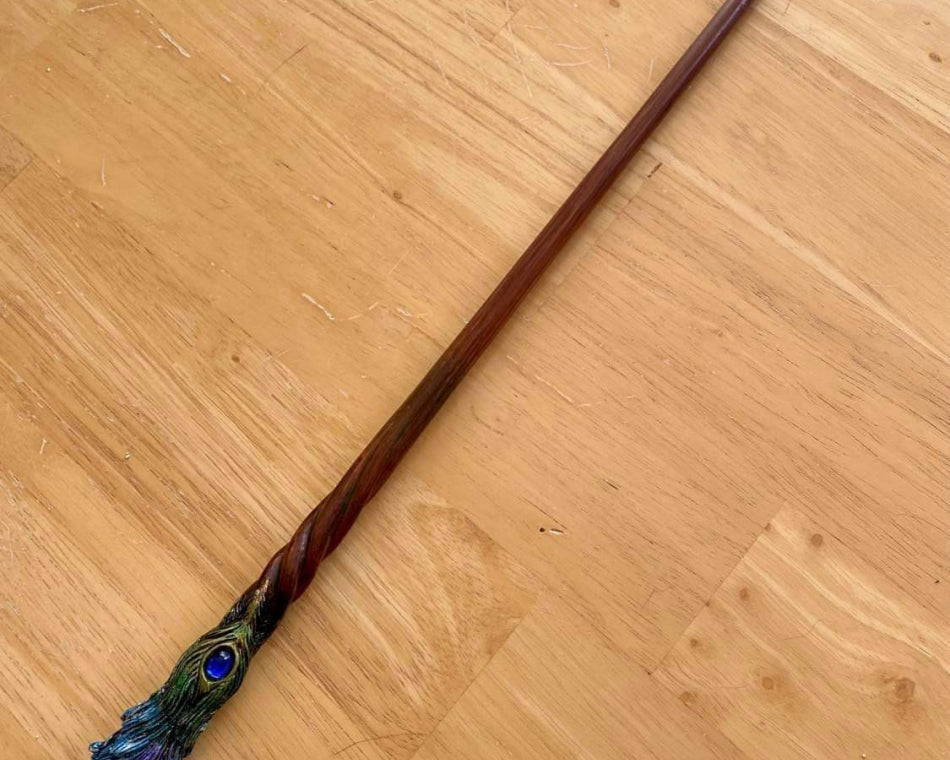 Combining dark brown wood with a peacock feather handle, this wand we sell is gorgeous!