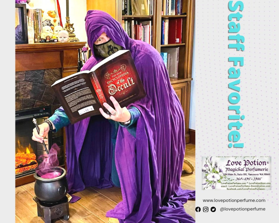 Ryan wearing a purple velvet robe as she reads a book and casts a spell in a cauldron.