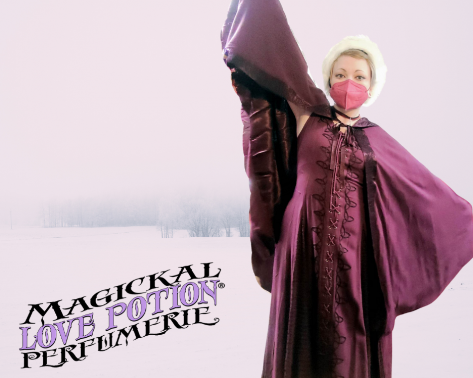 Kimi dons a deep red dress and matching cape with a fuzzy white headband.