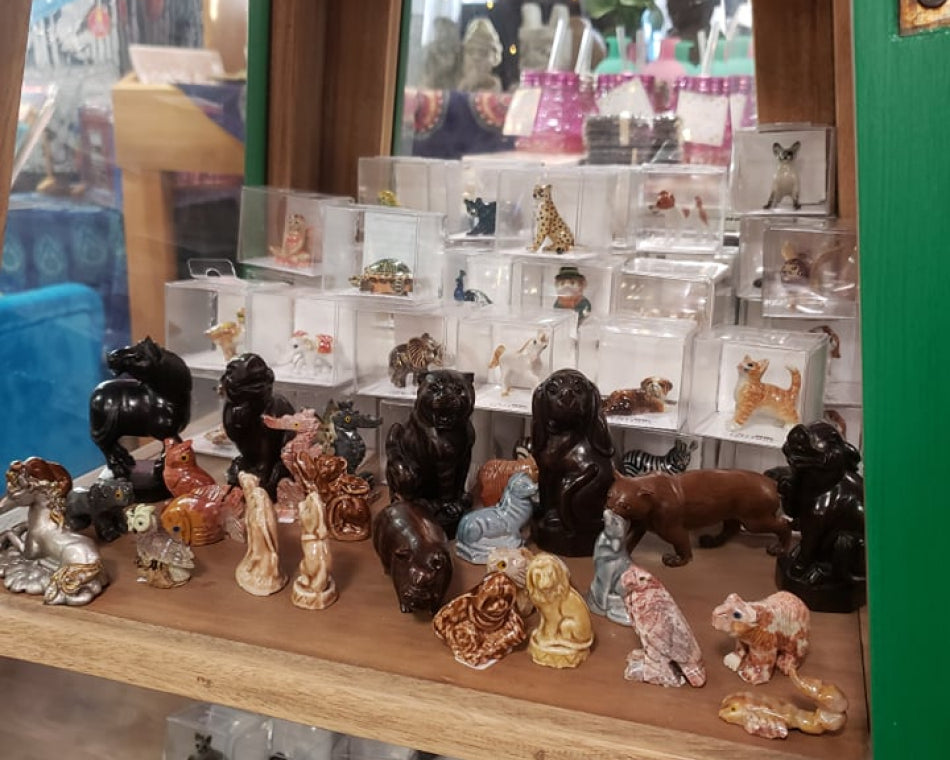 Decorative animal figurines made of glass, wood, and ceramic.