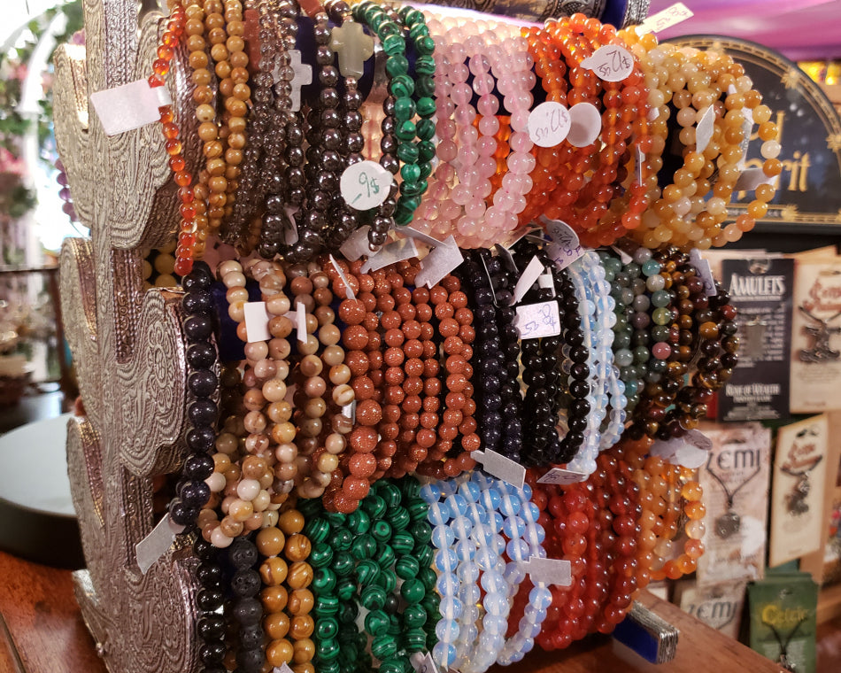 A range of crystal bead bracelets on a holder in the jewelry section.