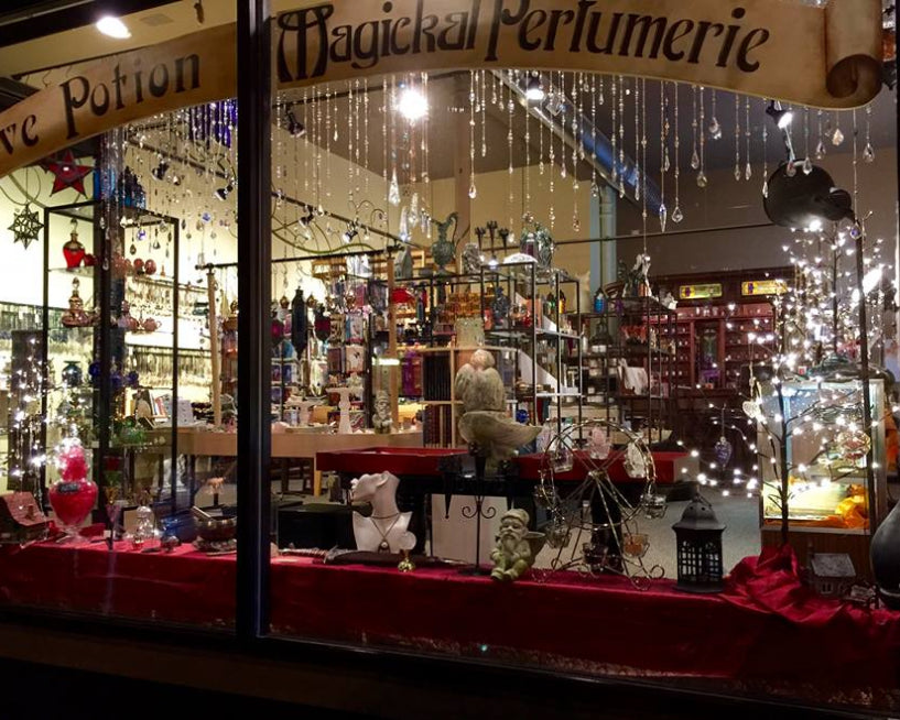 Love Potion Magical Perfumerie store front with various products and decorations, including crystal sun catchers.