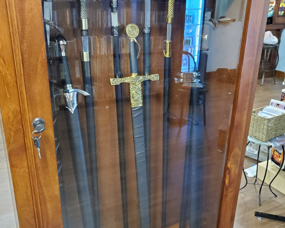 The image displays numerous canes and swords stored in a wooden case with a glass door.