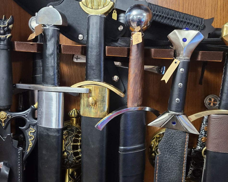 In the image, there is a wooden case showcasing unique swords and a small ax on the top.