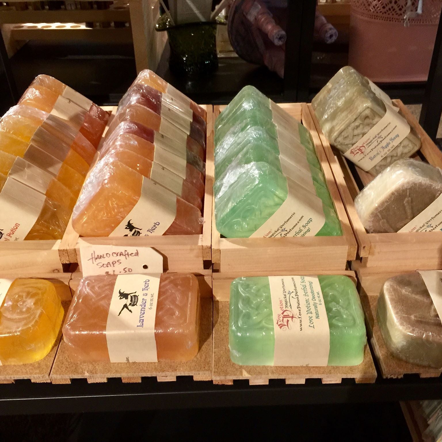 Handmade herbal soaps by Love Potion displayed on shelves in our Magickal Marketplace