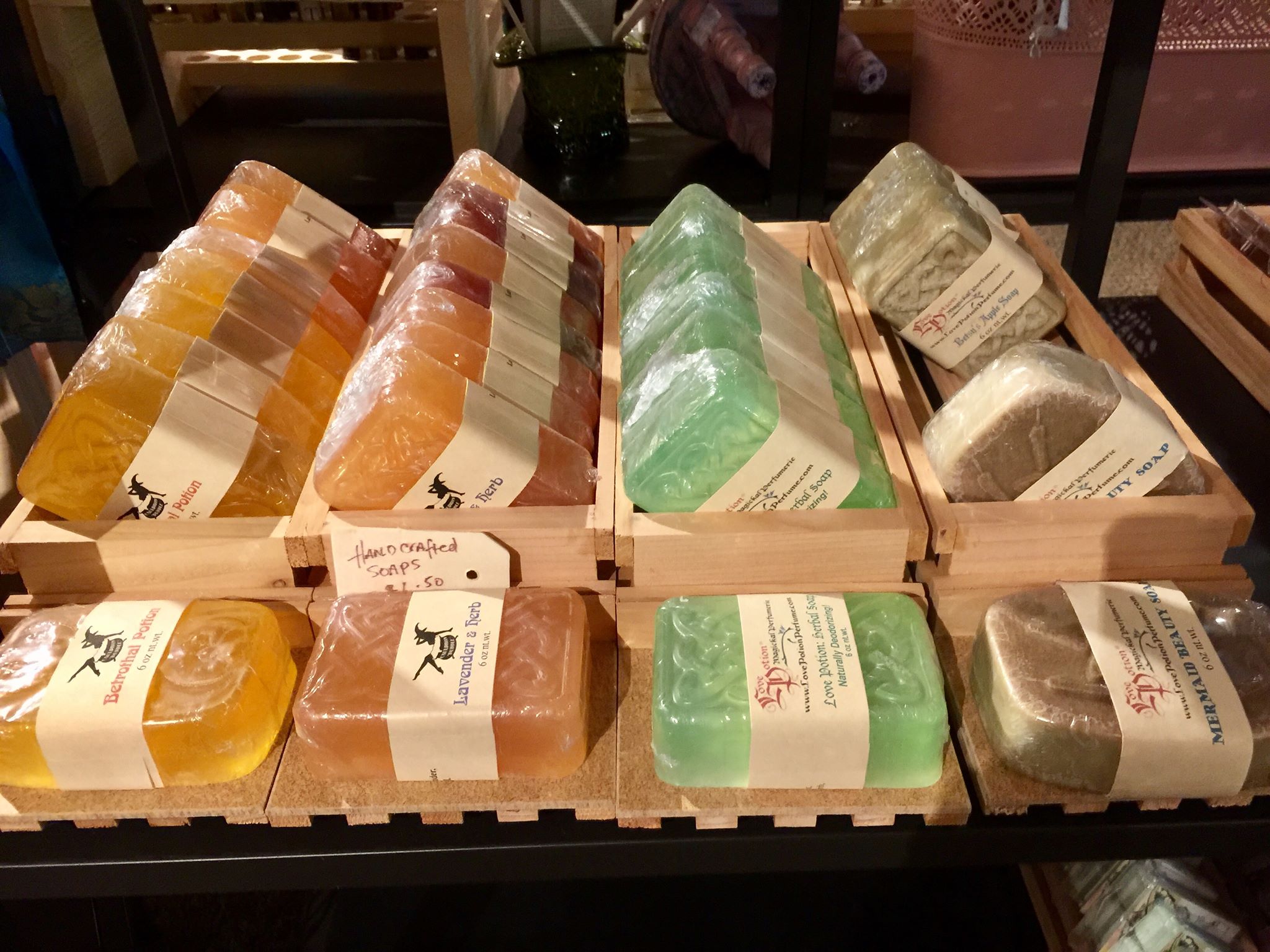 Handmade herbal soaps by Love Potion displayed on shelves in our Magickal Marketplace