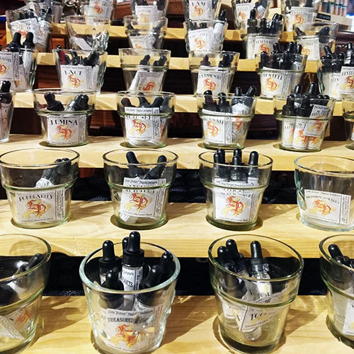 Photo showing a wood and glass display of pheromone product bottles.