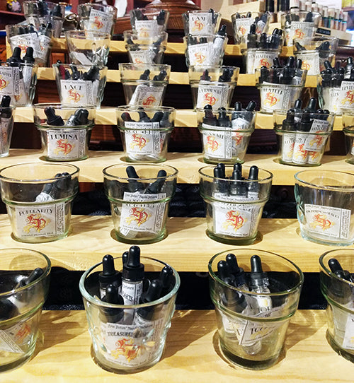 Photo showing a wood and glass display of pheromone product bottles.