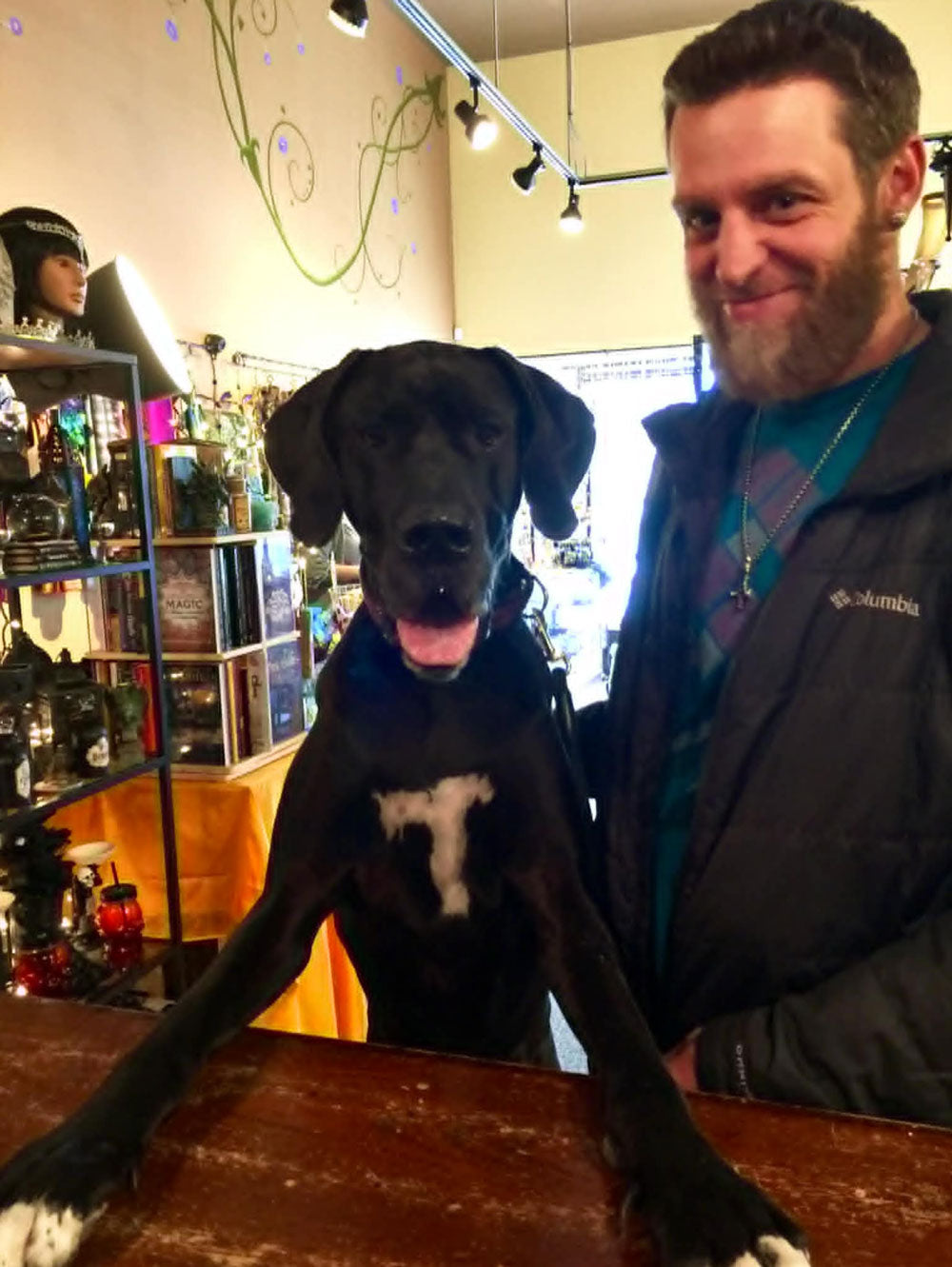 Customer with their black dog at the checkout counter of our store.