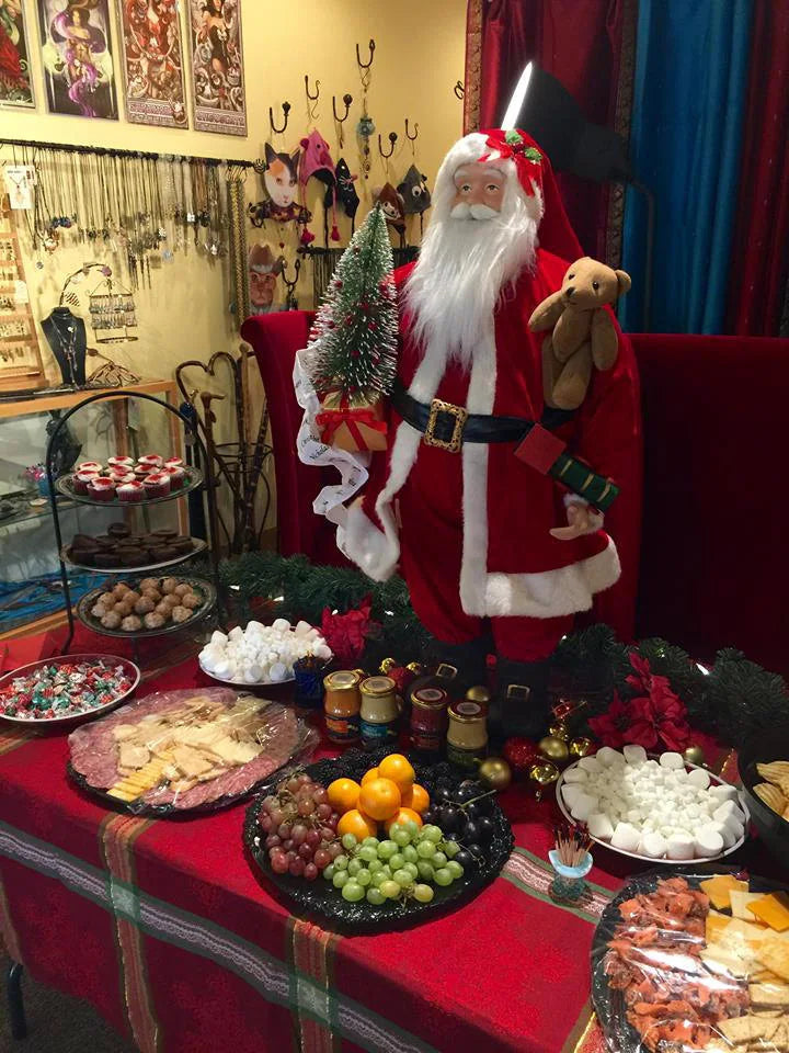Decorative setup with Santa Claus figure, food platters, and festive decorations in our store during a Christmas party.