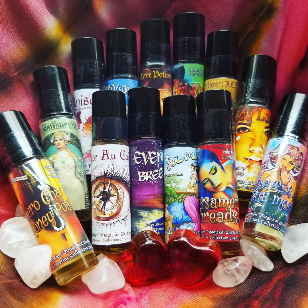 Collection of popular oil perfumes and pheromone bottles with crystals on a tie-dye cloth.