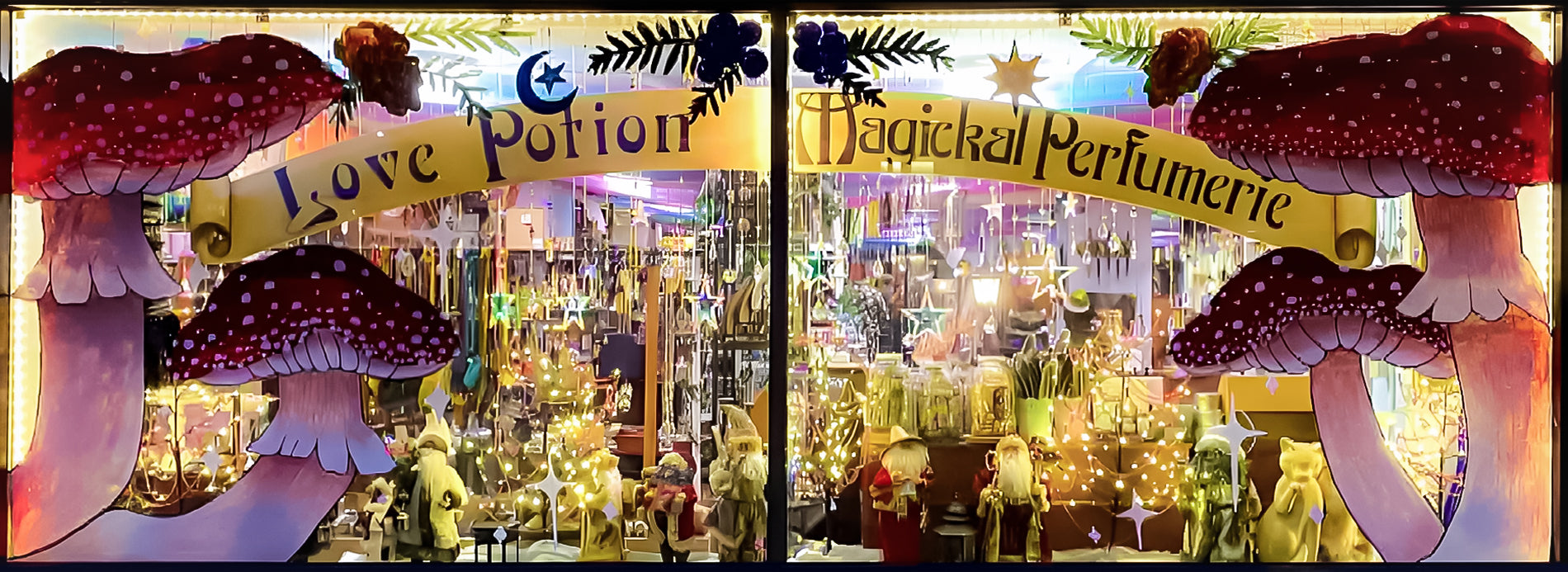 A full width image of the main window of our shop painted with magical mushrooms for fall and winter. You can see Christmas knickknacks inside.