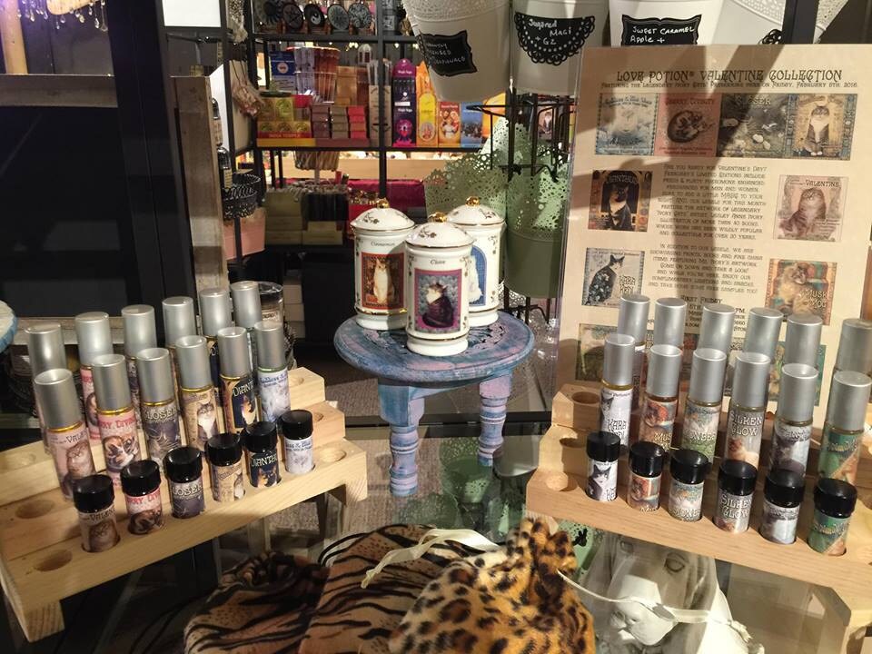 Valentine perfume display with sample roller bottles, vintage cat painting spice jars, and leopard & tiger print pouches.