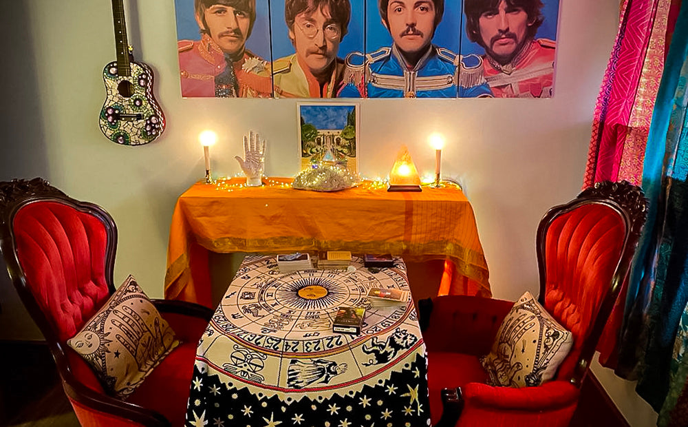 The divination area in our Room of Requirement, with red velvet chairs, a card table, and paintings of The Beatles on the wall.