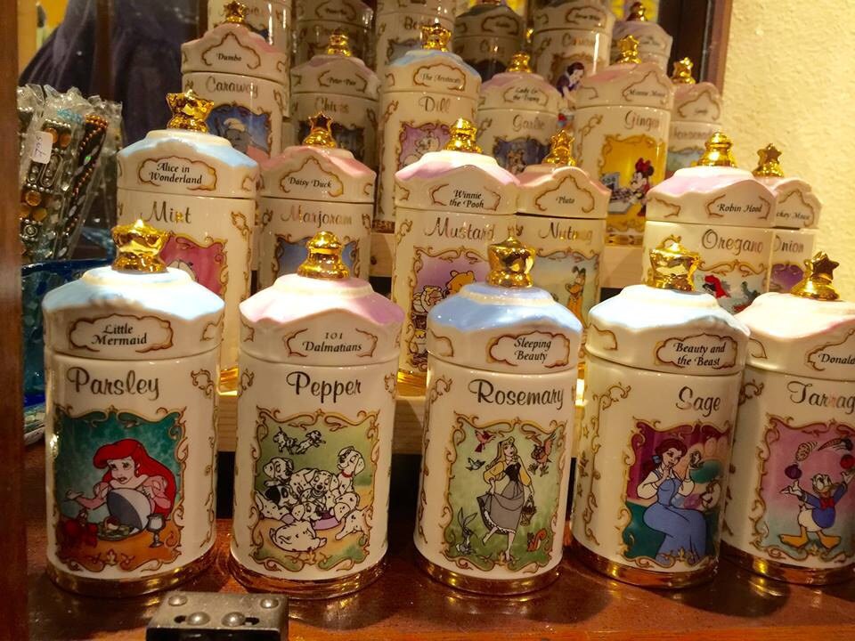 Collection of vintage spice jars with different Disney characters on each jar.