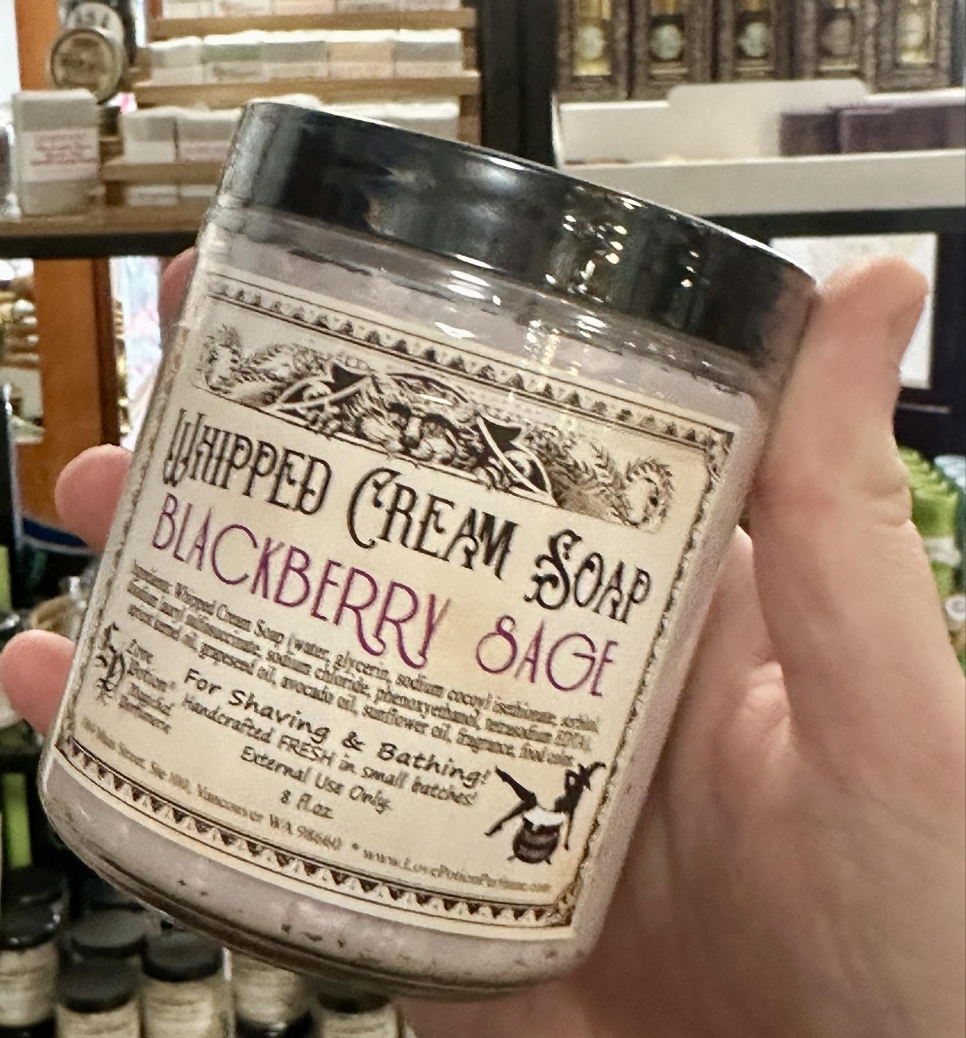 Love Potion whipped cream soap in a jar held by someone at the Love Potion Magickal Marketplace