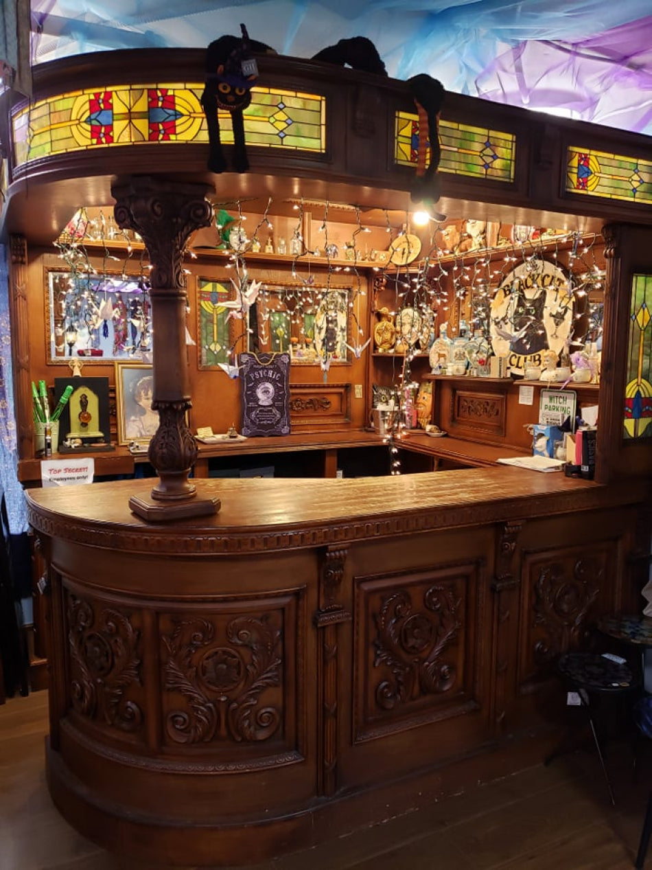 Wooden bar with stained glass panels and various magical decorations and fairy lights, custom-build for Love Potion.