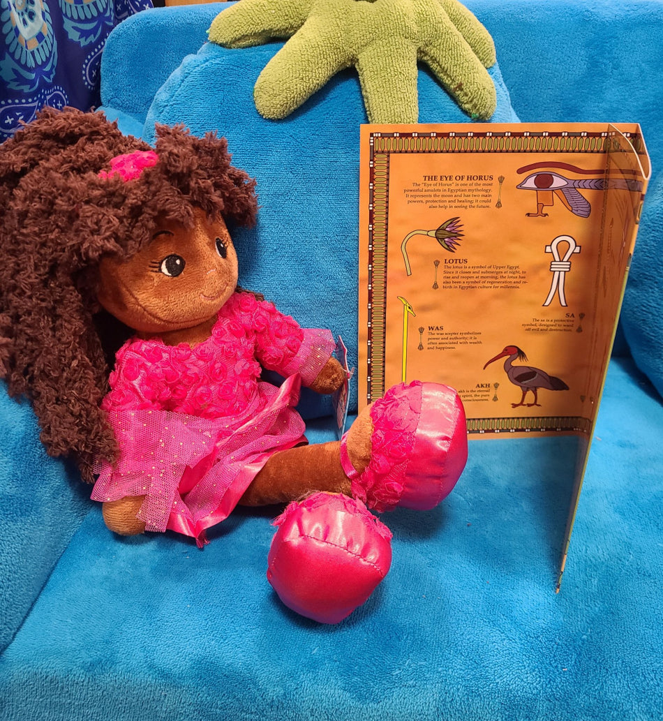 The picture showcases one of our charming dolls engrossed in a booklet about Egypt.