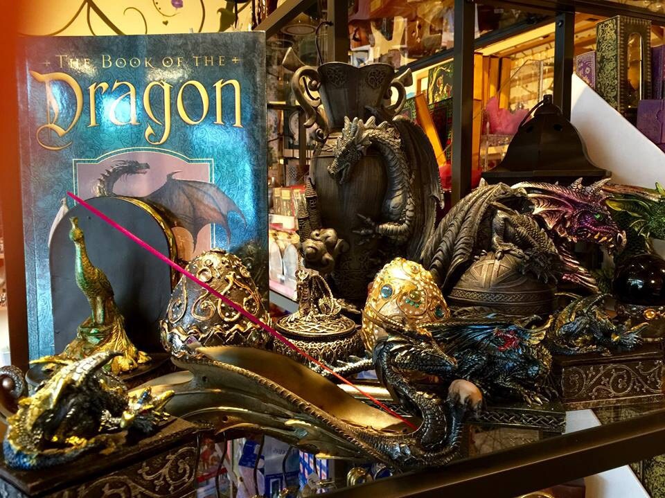 Decorative display with 'The Book of the Dragon' and dragon figurines, including dragon eggs and incense holders.