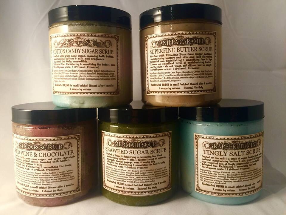 Collection of handmade Love Potion sugar scrubs with labels on a white background.