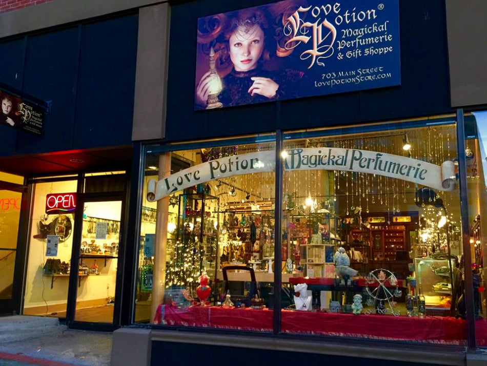 Storefront of Love Potion Magical Perfumerie & Gift Shoppe with decorative display and sign.